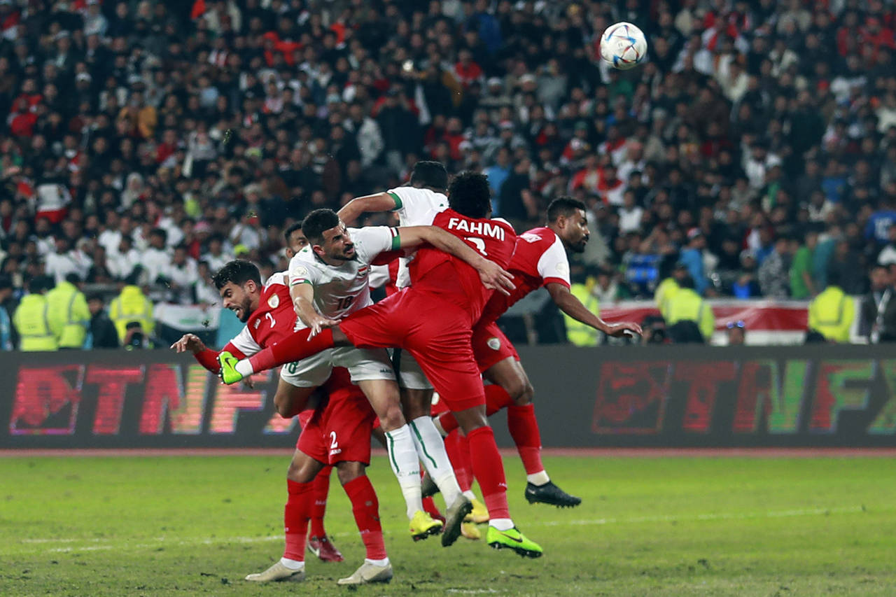 Iraq's Ayman Hussein, center, fights for the ball, during the Arabian Gulf Cup's final football mat...