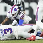 
              CLARIFIES THAT IMAGE SHOWN IS FROM THE END OF A TACKLE SECONDS BEFORE HAMLIN COLLAPSED - Buffalo Bills safety Damar Hamlin (3) lies on the turf after making a tackle on Cincinnati Bengals wide receiver Tee Higgins, blocked from view, as Buffalo Bills linebacker Tremaine Edmunds (49) assists at the end of the play during the first half of an NFL football game between the Cincinnati Bengals and the Buffalo Bills, Monday, Jan. 2, 2023, in Cincinnati. After getting up from the play, Hamlin collapsed and was administered CPR on the field. (AP Photo/Joshua A. Bickel)
            
