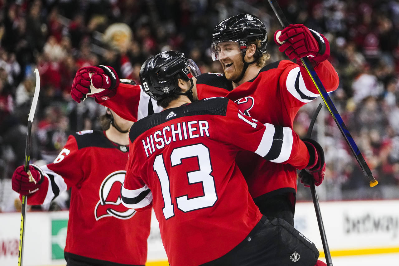 New Jersey Devils' Dougie Hamilton, right, celebrates with teammate Nico Hischier, center after sco...