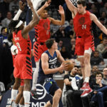 
              Minnesota Timberwolves center Luka Garza, center, goes up for a shot while being defended by Portland Trail Blazers forward Jerami Grant (9), guard Shaedon Sharpe (17) and center Drew Eubanks (24) during the first half of an NBA basketball game, Wednesday, Jan. 4, 2023, in Minneapolis. (AP Photo/Craig Lassig)
            