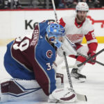 
              Colorado Avalanche goaltender Pavel Francouz, left, covers the puck with his glove as Detroit Red Wings defenseman Jordan Oesterle, center, drives to the net in the second period of an NHL hockey game Monday, Jan. 16, 2023, in Denver. (AP Photo/David Zalubowski)
            