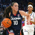 
              Connecticut's Nika Muhl (10) drives past St. John's Kadaja Bailey (30) during the second half of an NCAA basetball game Wednesday, Jan. 11, 2023, in New York. Connecticut won 82-52. (AP Photo/Frank Franklin II)
            