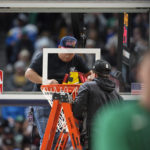 
              Workers struggle to replace the rim after it was bent during a dunk by Boston Celtics center Robert Williams III in the second half of an NBA basketball game against the Denver Nuggets, Sunday, Jan. 1, 2023, in Denver. (AP Photo/David Zalubowski)
            