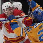 
              Calgary Flames' Michael Stone, left, collides with St. Louis Blues' Nathan Walker during the second period of an NHL hockey game Tuesday, Jan. 10, 2023, in St. Louis. (AP Photo/Jeff Roberson)
            