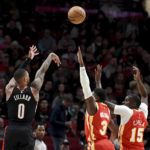
              Portland Trail Blazers guard Damian Lillard, left, shoots a basket over Atlanta Hawks guard Aaron Holiday, center, and center Clint Capela, right, during the first half of an NBA basketball game in Portland, Ore., Monday, Jan. 30, 2023. (AP Photo/Steve Dykes)
            
