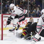 
              Chicago Blackhawks' Jason Dickinson, left, jumps over Vancouver Canucks goalie Collin Delia to avoid a collision during the second period of an NHL hockey game Tuesday, Jan. 24, 2023, in Vancouver, British Columbia. (Darryl Dyck/The Canadian Press via AP)
            