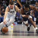 
              Dallas Mavericks guard Luka Doncic (77) and New Orleans Pelicans forward Herbert Jones (5) chase a loose ball in the first half during an NBA basketball game on Saturday, Jan. 7, 2023, in Dallas. (AP Photo/Richard W. Rodriguez)
            