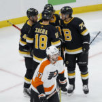 
              Philadelphia Flyers center Zack MacEwen skates away as Boston Bruins players congratulate Pavel Zacha (18) after he scored a goal during the second period of an NHL hockey game, Monday, Jan. 16, 2023, in Boston. (AP Photo/Mary Schwalm)
            