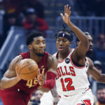 
              Cleveland Cavaliers guard Donovan Mitchell (45) passes against Chicago Bulls guard Ayo Dosunmu (12) during the first half of an NBA basketball game, Monday, Jan. 2, 2023, in Cleveland. (AP Photo/Ron Schwane)
            