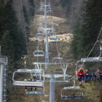 
              People ride the cable car above the ski track without any snow on Bjelasnica mountain near Sarajevo, Bosnia, Wednesday, Jan. 4, 2023. (AP Photo/Armin Durgut)
            