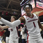 
              Arkansas' Ricky Council IV (1) and Joseph Pinion (5) celebrate with fans after Arkansas defeated Missouri 74-68 during an NCAA college basketball game Wednesday, Jan. 4, 2023, in Fayetteville, Ark. (AP Photo/Michael Woods)
            
