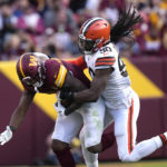
              Cleveland Browns defensive end Jadeveon Clowney (90) tackles Washington Commanders running back Brian Robinson Jr. (8) during the second half of an NFL football game, Sunday, Jan. 1, 2023, in Landover, Md. (AP Photo/Susan Walsh)
            