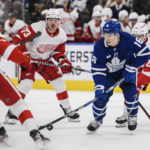 
              Toronto Maple Leafs right wing Mitchell Marner (16) controls the puck as Detroit Red Wings center Oskar Sundqvist (70), left wing Adam Erne (73) and center Pius Suter (24) defend during the second period of an NHL hockey game Saturday, Jan. 7, 2023, in Toronto. (Christopher Katsarov/The Canadian Press via AP)
            
