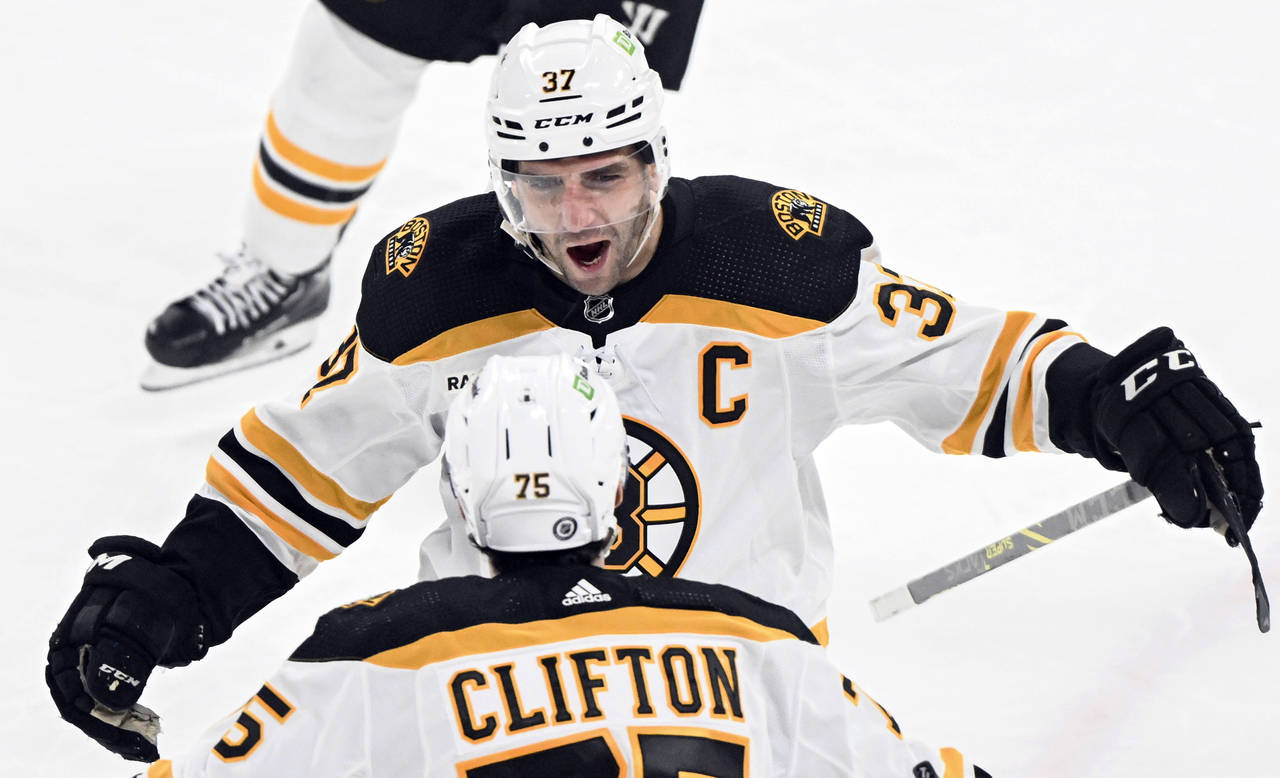 Boston Bruins' Patrice Bergeron (37) celebrates with teammate Connor Clifton after scoring against ...