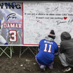 
              Fans leave messages of support for Buffalo Bills safety Damar Hamlin (3) on a poster outside Highmark Stadium before an NFL football game against the New England Patriots, Sunday, Jan. 8, 2023, in Orchard Park, N.Y. Hamlin remains hospitalized after suffering a catastrophic on-field collapse in the team's previous game against the Cincinnati Bengals. (AP Photo/Adrian Kraus)
            