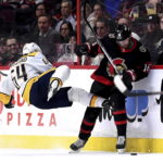 
              Nashville Predators center Mikael Granlund (64) is thrown backward after a check by Ottawa Senators left wing Austin Watson (16) during second-period NHL hockey game action in Ottawa, Ontario, Monday, Jan. 9, 2023. (Justin Tang/The Canadian Press via AP)
            