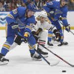 
              St. Louis Blues' Jake Neighbours (63) vies for the puck against Chicago Blackhawks' Jack Johnson (8) during the second period of an NHL hockey game Saturday, Jan. 21, 2023, in St. Louis. (AP Photo/Michael Thomas)
            