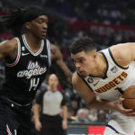 
              Denver Nuggets forward Michael Porter Jr., right, is defended by Los Angeles Clippers guard Terance Mann (14) during the second half of an NBA basketball game Friday, Jan. 13, 2023, in Los Angeles. (AP Photo/Marcio Jose Sanchez)
            
