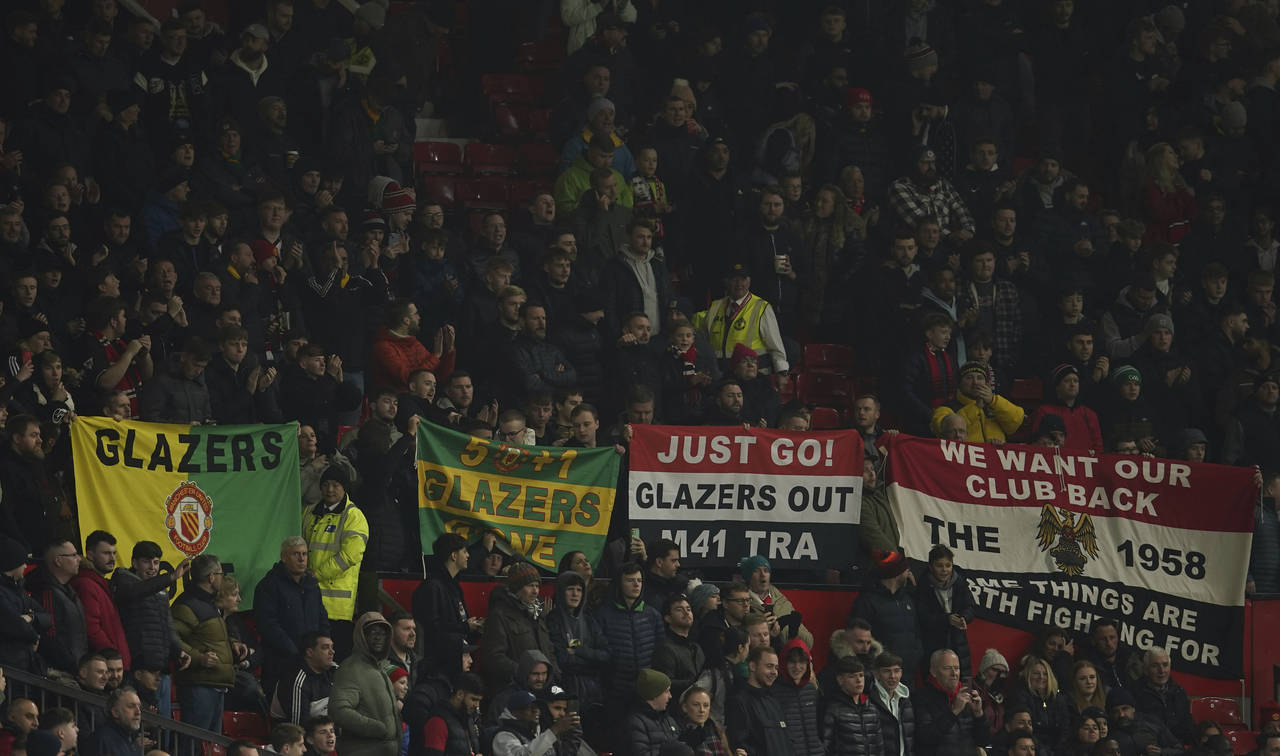 Manchester United fans hold up banners against the current owners of the club the Glazers, just ahe...