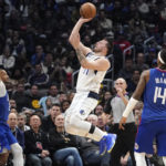 
              Dallas Mavericks guard Luka Doncic, center, shoots as Los Angeles Clippers forward Norman Powell, left, and guard Terance Mann defend during the second half of an NBA basketball game Tuesday, Jan. 10, 2023, in Los Angeles. (AP Photo/Mark J. Terrill)
            