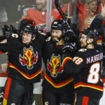 
              Calgary Flames forward Dillon Dube, center, celebrates his game-winning goal with teammates forward Jakob Pelletier, left, and forward Andrew Mangiapane in overtime of an NHL hockey game against the Columbus Blue Jackets in Calgary, Alberta, Monday, Jan. 23, 2023. (Jeff McIntosh/The Canadian Press via AP)
            