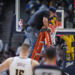 
              A worker uses a level to check the rim after it was bent by a dunk by Boston Celtics center Robert Williams III in the second half of an NBA basketball game against the Denver Nuggets, Sunday, Jan. 1, 2023, in Denver. (AP Photo/David Zalubowski)
            