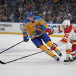 
              St. Louis Blues' Colton Parayko (55) and Calgary Flames' MacKenzie Weegar (52) chase after a loose puck during the second period of an NHL hockey game Tuesday, Jan. 10, 2023, in St. Louis. (AP Photo/Jeff Roberson)
            