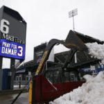 
              Crews clear snow from a parking lot near a sign showing support for Buffalo Bills safety Damar Hamlin outside Highmark Stadium on Wednesday, Jan. 4, 2023, in Orchard Park, N.Y. (AP Photo/Joshua Bessex)
            