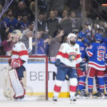 
              Florida Panthers goaltender Alex Lyon, left, and Radko Gudas, center, react as the New York Rangers celebrate a goal by Mika Zibanejad during the third period of an NHL hockey game Monday, Jan. 23, 2023, in New York. (AP Photo/Frank Franklin II)
            
