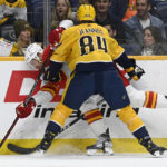 
              Nashville Predators left wing Tanner Jeannot (84) checks Calgary Flames center Trevor Lewis, left, into the boards during the first period of an NHL hockey game Monday, Jan. 16, 2023, in Nashville, Tenn. (AP Photo/Mark Zaleski)
            