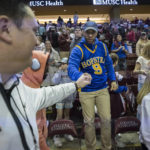 
              Hofstra fan Sammy Martin, center, fist bumps a team member after the second half of an NCAA college basketball game against Charleston, Saturday, Jan. 28, 2023, in Charleston, S.C. (AP Photo/Stephen B. Morton)
            