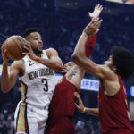 
              New Orleans Pelicans guard CJ McCollum (3) looks to pass the ball against Cleveland Cavaliers forward Isaac Okoro, center, and center Jarrett Allen, right, during the first half of an NBA basketball game, Monday, Jan. 16, 2023, in Cleveland. (AP Photo/Ron Schwane)
            