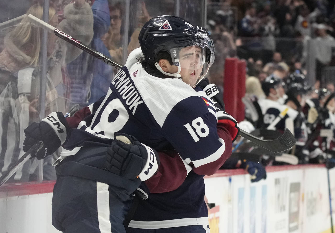 Colorado Avalanche center Alex Newhook, front, is hugged by center Andrew Cogliano after scoring a ...