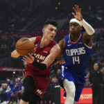 
              Miami Heat guard Tyler Herro, left, drives to the basket against Los Angeles Clippers guard Terance Mann during the first half of an NBA basketball game, Monday, Jan. 2, 2023, in Los Angeles. (AP Photo/Allison Dinner)
            
