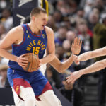 
              Denver Nuggets center Nikola Jokic, front left, is caught with the ball by Cleveland Cavaliers center Jarrett Allen, back left, and forward Kevin Love in the first half of an NBA basketball game Friday, Jan. 6, 2023, in Denver. (AP Photo/David Zalubowski)
            