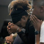 
              A woman prays during a prayer service for Buffalo Bills' Damar Hamlin at Crossroads Uptown Church, Tuesday, Jan. 3, 2023, in Cincinnati. The family of Damar Hamlin expressed gratitude for the outpouring of support shown toward the Buffalo Bills safety who suffered cardiac arrest after making a tackle while asking everyone to keep the hospitalized player in their prayers on Tuesday. (AP Photo/Darron Cummings)
            