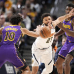 
              Denver Nuggets guard Jamal Murray, center, fights for control of the ball with Los Angeles Lakers guard Max Christie, left, and center Thomas Bryant in the first half of an NBA basketball game Monday, Jan. 9, 2023, in Denver. (AP Photo/David Zalubowski)
            