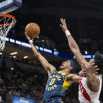 
              Indiana Pacers guard Tyrese Haliburton (0) shoots while being defended by Toronto Raptors forward Scottie Barnes during the second half of an NBA basketball game in Indianapolis, Monday, Jan. 2, 2023. (AP Photo/Doug McSchooler)
            