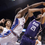 
              TCU forward JaKobe Coles (21) hangs back for a shot as Kansas center Ernest Udeh Jr. (23) defends during the second half of an NCAA college basketball game on Saturday, Jan. 21, 2023, at Allen Fieldhouse in Lawrence, Kan. TCU defeated Kansas, 83-60. (AP Photo/Nick Krug)
            