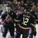 
              Arizona Coyotes right wing Christian Fischer, left, celebrates his goal against the San Jose Sharks with Coyotes left wing Nick Ritchie (12) and Coyotes defenseman Jakob Chychrun, back right, during the first period of an NHL hockey game in Tempe, Ariz., Tuesday, Jan. 10, 2023. (AP Photo/Ross D. Franklin)
            