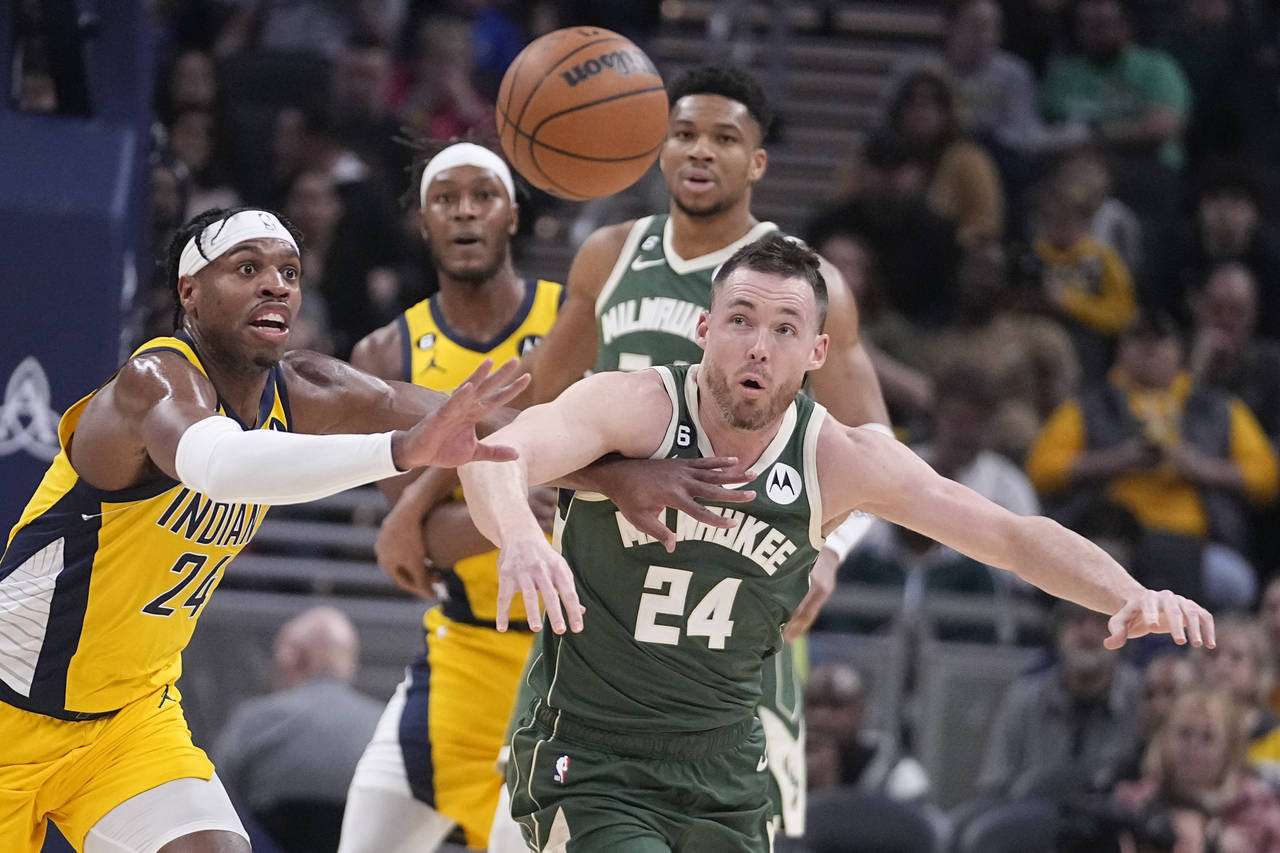 Indiana Pacers' Buddy Hield (24) and Milwaukee Bucks' Pat Connaughton (24) via for a loose ball dur...