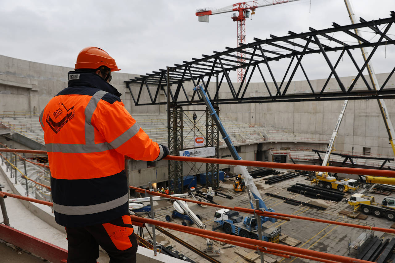 A worker looks at the Paris2024 Olympics Porte de la Chapelle Arena building site Monday, Jan. 23, ...