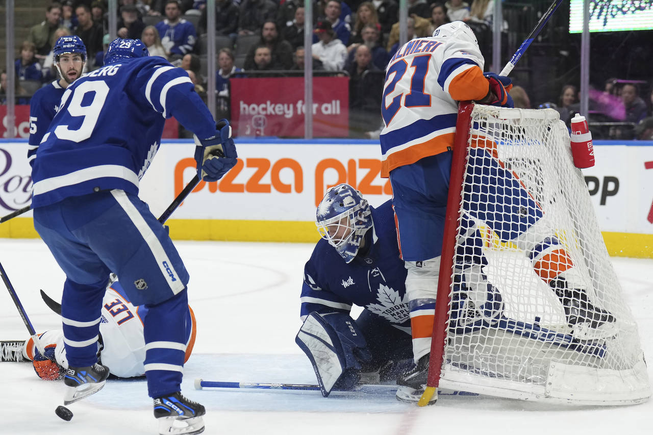 New York Islanders center Kyle Palmieri (21) crashes into Toronto Maple Leafs goaltender Ilya Samso...