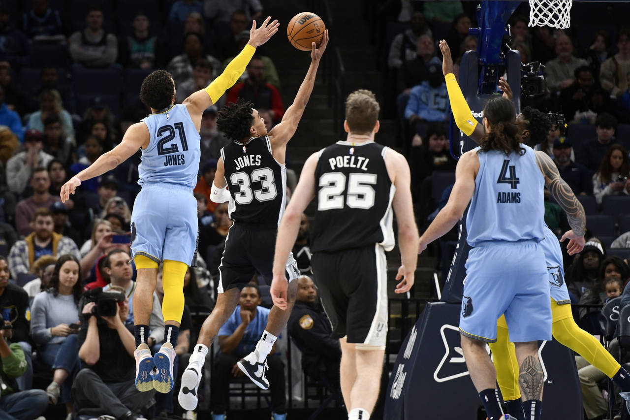 San Antonio Spurs guard Tre Jones (33) shoots ahead of his brother Memphis Grizzlies guard Tyus Jon...