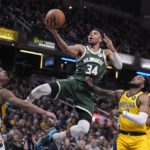 
              Milwaukee Bucks' Giannis Antetokounmpo (34) puts up a shot against Indiana Pacers' Andrew Nembhard (2) and Oshae Brissett (12) during the second half of an NBA basketball game, Friday, Jan. 27, 2023, in Indianapolis. (AP Photo/Darron Cummings)
            