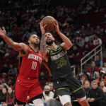 
              Minnesota Timberwolves' Austin Rivers (25) goes up for a shot as Houston Rockets' Eric Gordon (10) defends during the first half of an NBA basketball game Sunday, Jan. 8, 2023, in Houston. (AP Photo/David J. Phillip)
            