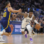 
              Memphis Grizzlies guard Ja Morant, right, drives to the basket against Golden State Warriors guard Stephen Curry during the first half of an NBA basketball game in San Francisco, Wednesday, Jan. 25, 2023. (AP Photo/Godofredo A. Vásquez)
            