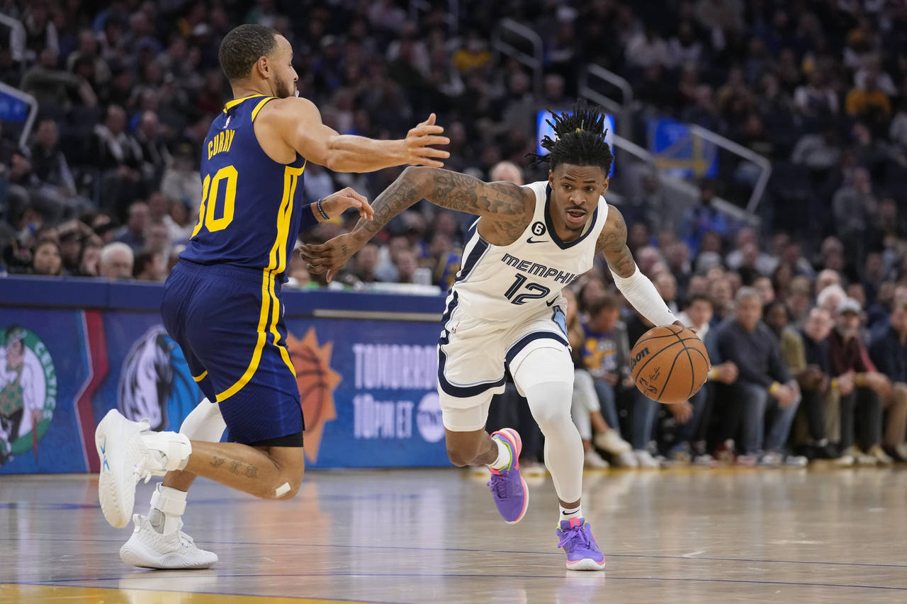 Memphis Grizzlies guard Ja Morant, right, drives to the basket against Golden State Warriors guard ...