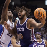
              TCU center Eddie Lampkin Jr. (4) works his way inside against Kansas center Ernest Udeh Jr. (23) during the second half of an NCAA college basketball game on Saturday, Jan. 21, 2023, at Allen Fieldhouse in Lawrence, Kan. TCU defeated Kansas, 83-60. (AP Photo/Nick Krug)
            
