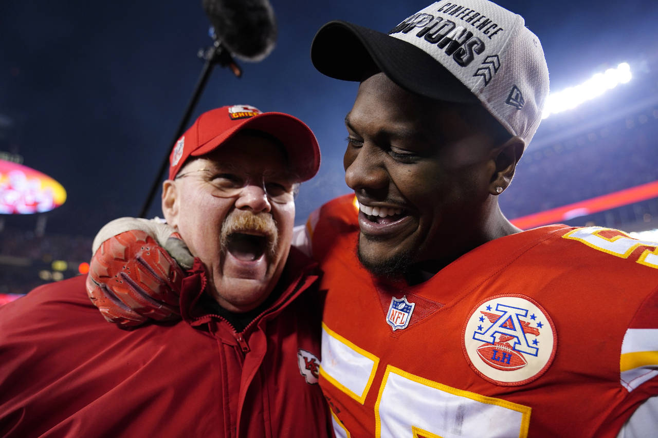 Kansas City Chiefs head coach Andy Reid celebrates with defensive end Frank Clark, right, after the...